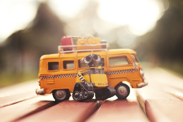 Showing Wall-E infront of a yellow VW bus with taxi stripes